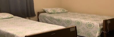 Two twin beds in a simple resident room.