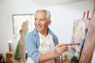 Senior man painting in an art studio.
