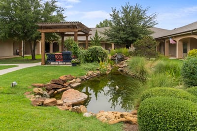 Outdoor garden area with seating and pond