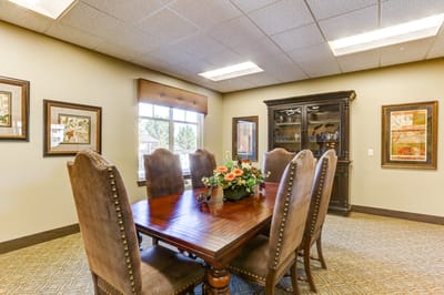 Elegant common dining area with wooden table and chairs.