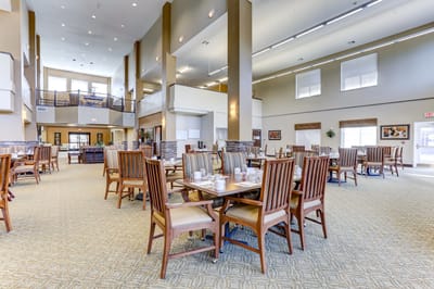 Spacious common area with dining tables and chairs.