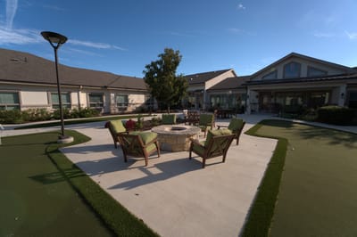 Outdoor seating area with fire pit and landscaping.