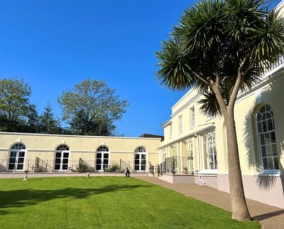 Exterior view of Arcot House Care Home with manicured gardens