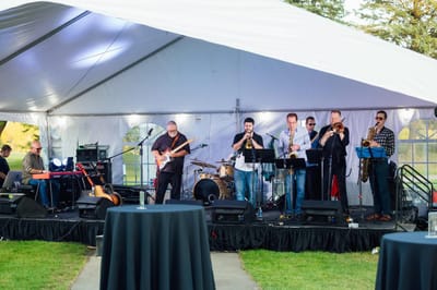Live band performing under a tent at an outdoor event