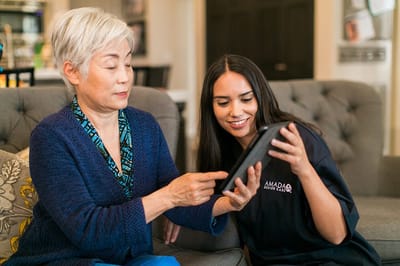 Resident and staff member using a tablet together