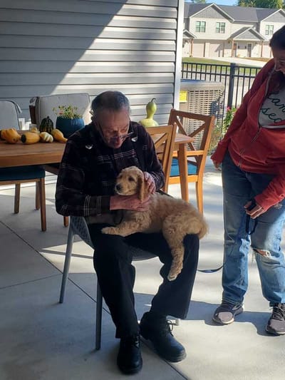 Resident enjoying time with a puppy outside