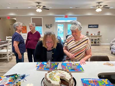 Residents celebrating with cake and decorations in a common area