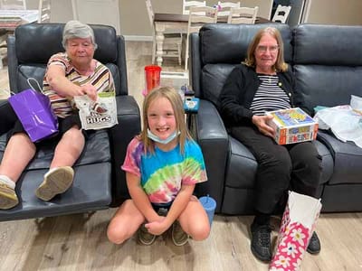 Residents and a child in a common area with gifts