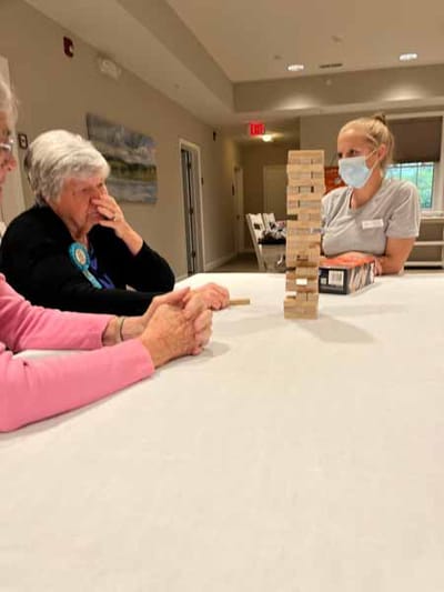 Residents and staff playing Jenga in a common area