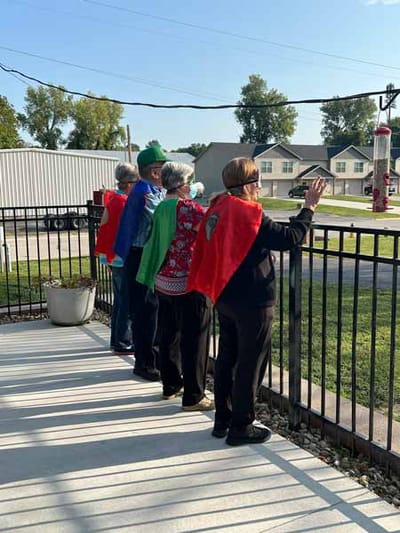 Residents enjoying an outdoor view wearing capes
