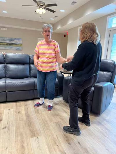 Resident interacting with staff in a cozy lounge area