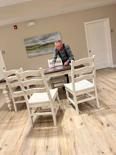 Resident enjoying a game at a table in activity space