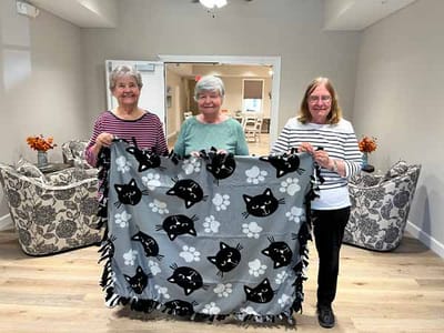 Residents creating a blanket in a common area