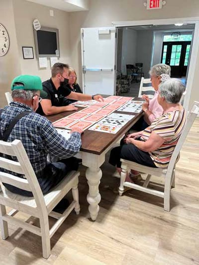 Residents and staff playing bingo around a table