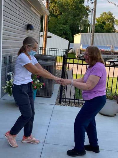 Staff and resident engaging in dance activity outdoors