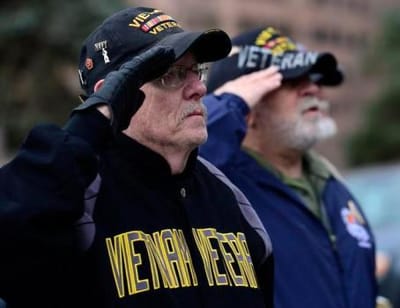 Veterans saluting during an event.