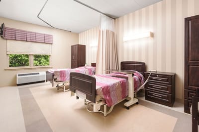 Patient room with two beds and window view.