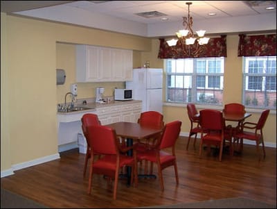 Dining area with red chairs and kitchen space