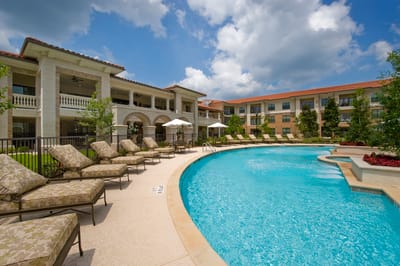 Sunny pool area with lounge chairs and shaded umbrellas