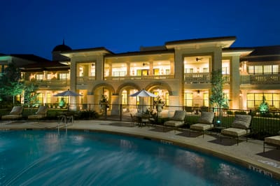 Exterior view of the facility with a pool at night