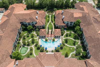 Aerial view of landscaped grounds with buildings and pool