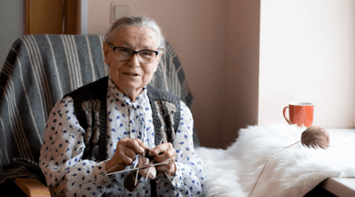 Resident knitting indoors by a window