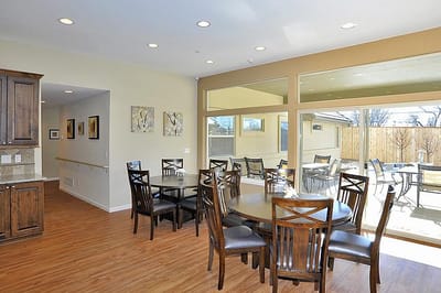 Bright common area with dining tables and large windows