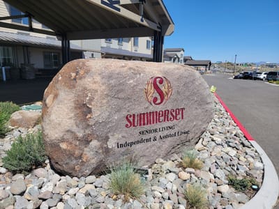Facility sign on a large rock in front of the building