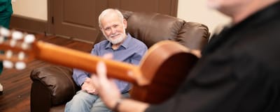 A resident enjoying music performance in a cozy lounge.