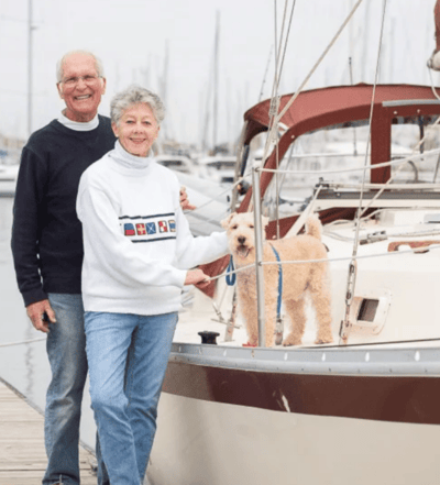 Older couple enjoying time on a sailboat with their dog