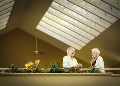 Two residents chatting in a bright interior space