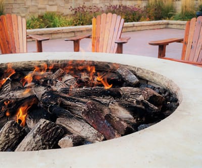 Fire pit surrounded by wooden chairs in an outdoor space
