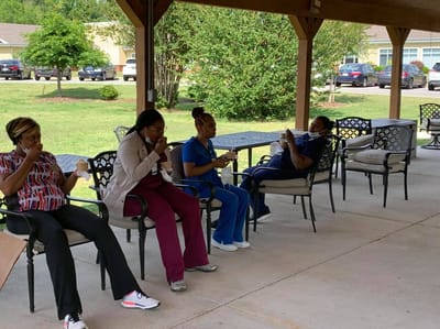 Amedisys Home Health Care, home care in Huntsville, AL — Healthcare workers enjoying refreshments under a covered patio