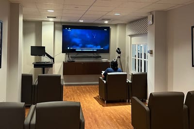 Resident watching a movie in a common area