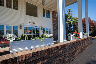 Exterior view of Countryside Manor with flowers and columns