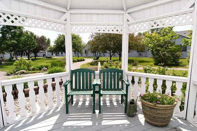 Outdoor gazebo with benches and greenery