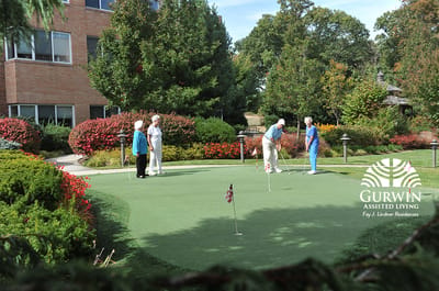 Residents playing golf in a beautifully landscaped garden
