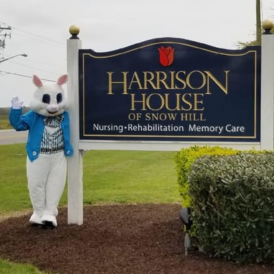 A person in a bunny costume next to the facility sign