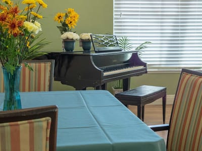 Interior view of a common area with piano and flowers