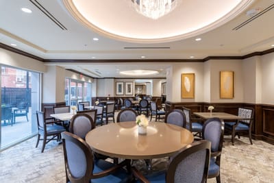 Dining area with tables and chairs in a senior living facility