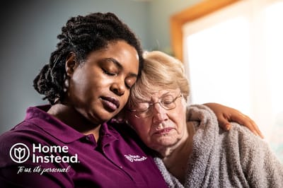 A caregiver and resident sharing a tender moment indoors