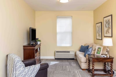 Cozy living area in a resident room with a sofa and TV