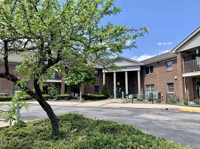 Exterior view of a senior living facility with green landscaping