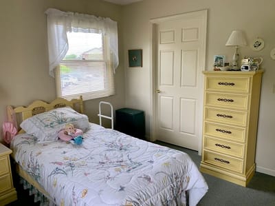 Cozy private resident room with a floral bedspread
