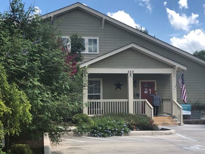 Exterior view of a senior living facility with a resident