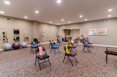 Exercise room set up for a class with chairs and weights