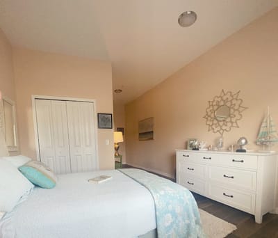 Brightly decorated resident bedroom with a bed and dresser