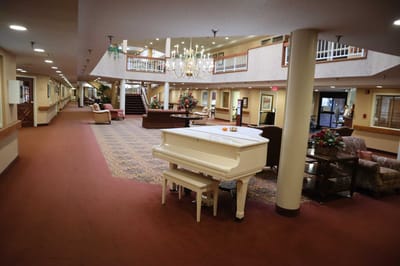Interior view of a common area with a piano and seating