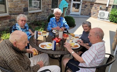 Residents enjoying a meal outside on the patio