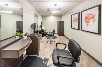 Bright hair salon interior with styling chairs and artwork